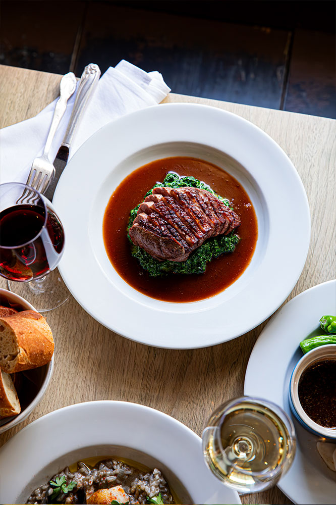 A dish of duck breast with creamed spinach at Chez Nous.